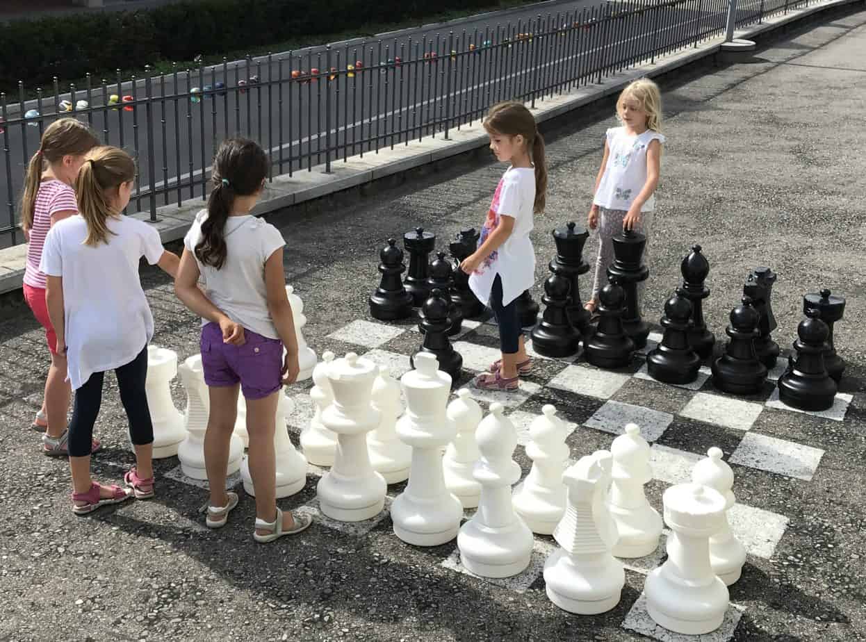 Mädchen spielen eine Beratungspartie am Freiluftschachbrett